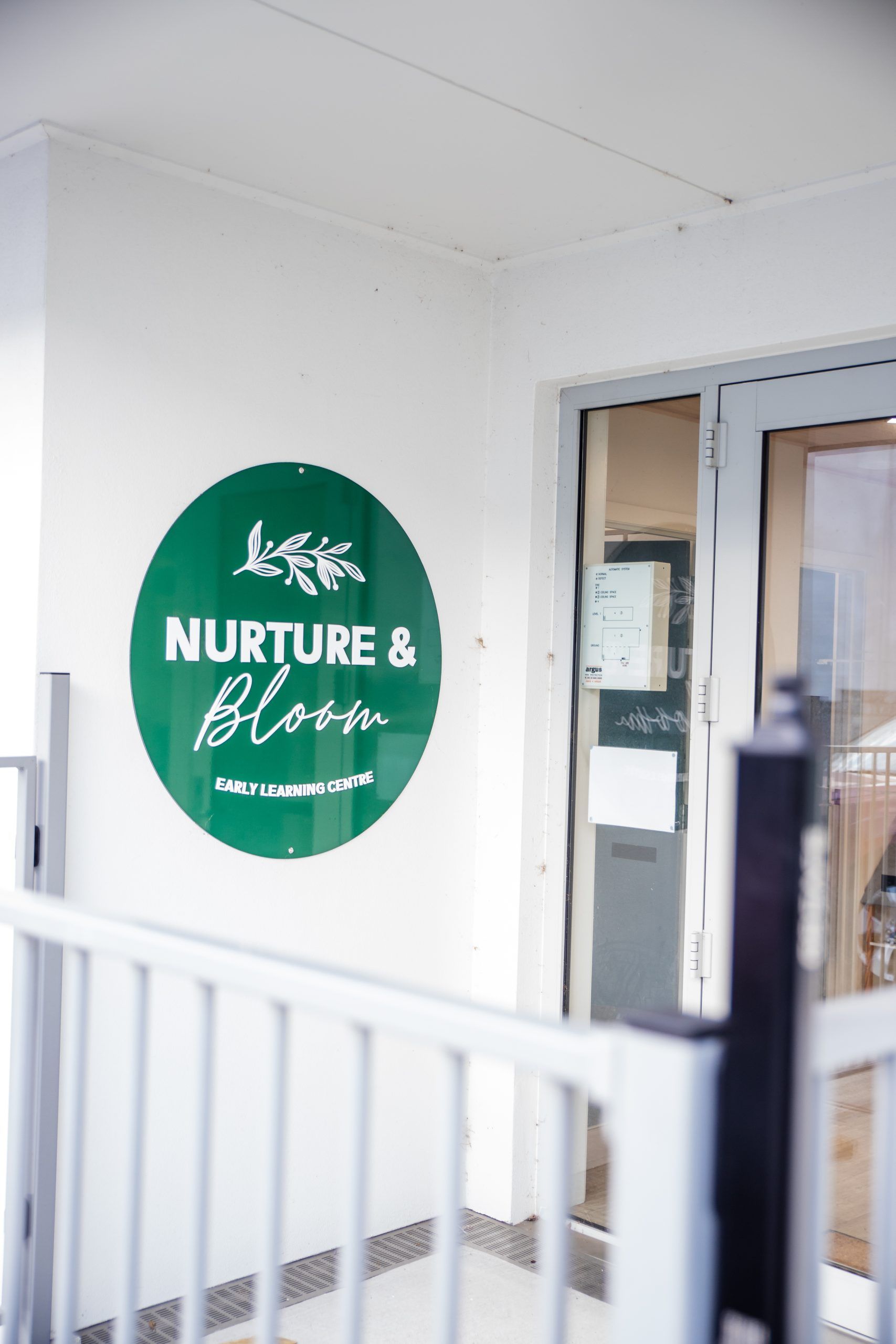 Nurture and Bloom | Outside entrance to our purpose built childcare centre with logo on wall
