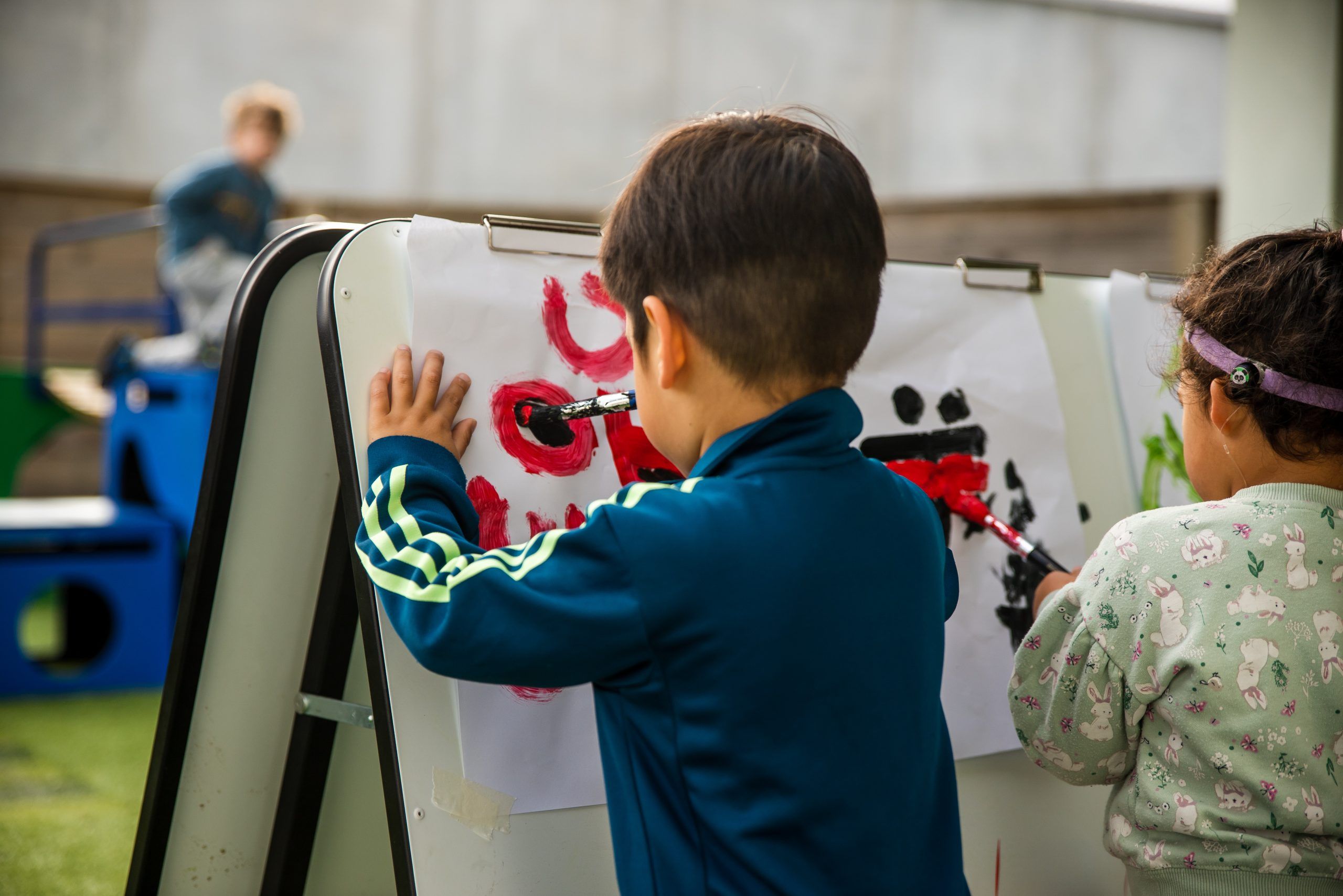 Nurture and Bloom | Children painting outside on easel