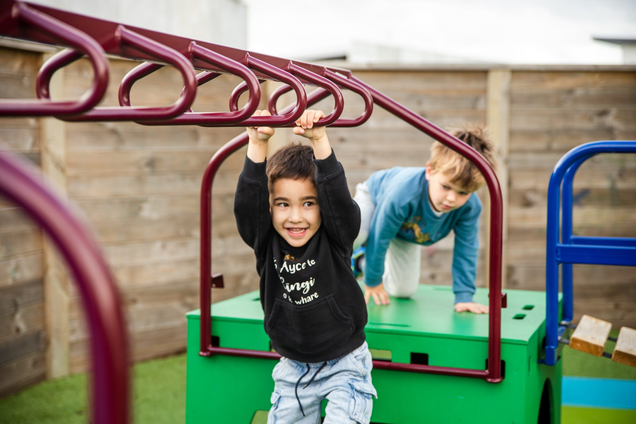 Nurture and Bloom | Kid playing on monkeys bars in playground