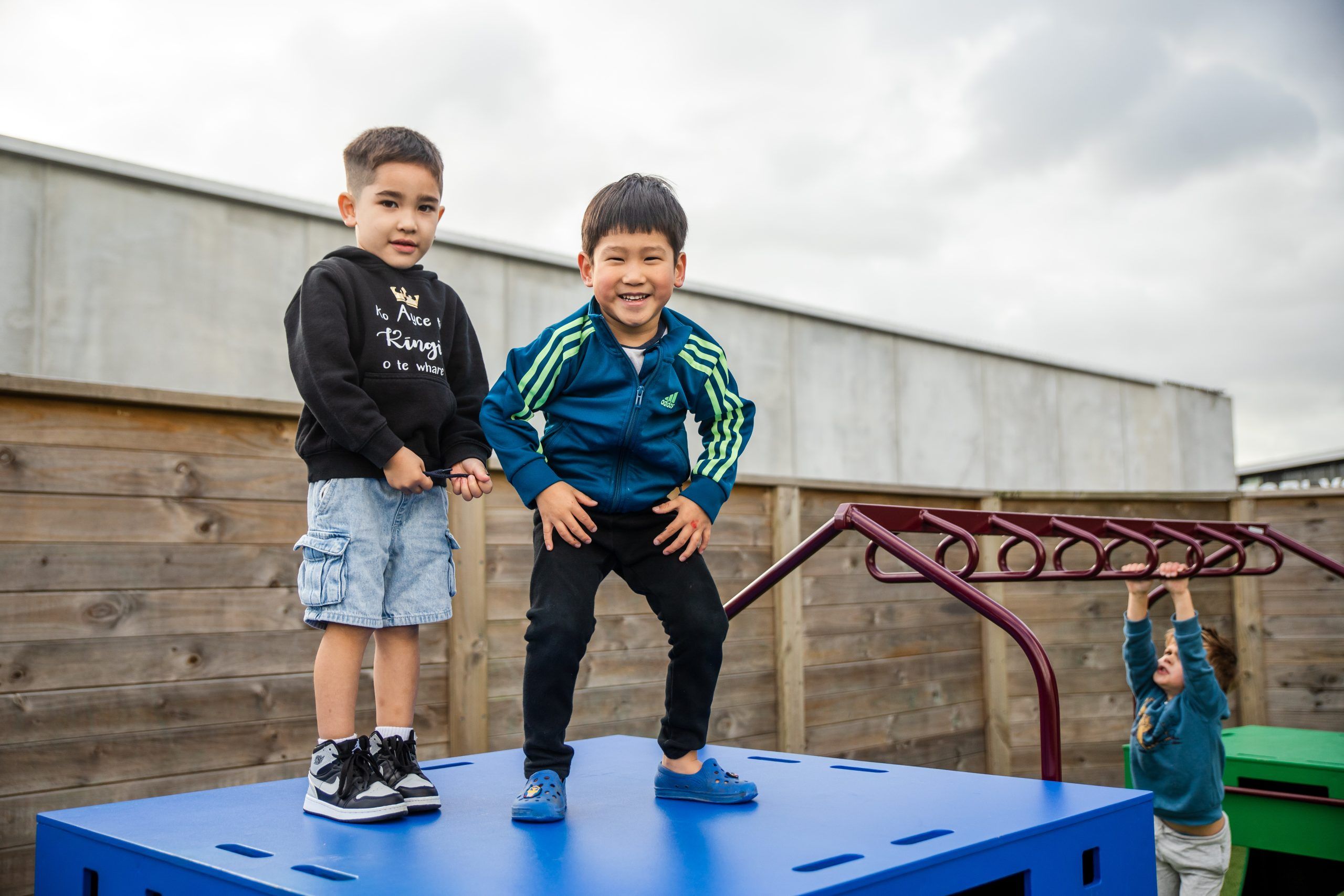 Nurture and Bloom | Kids playing on outdoor play equipment with monkey bars