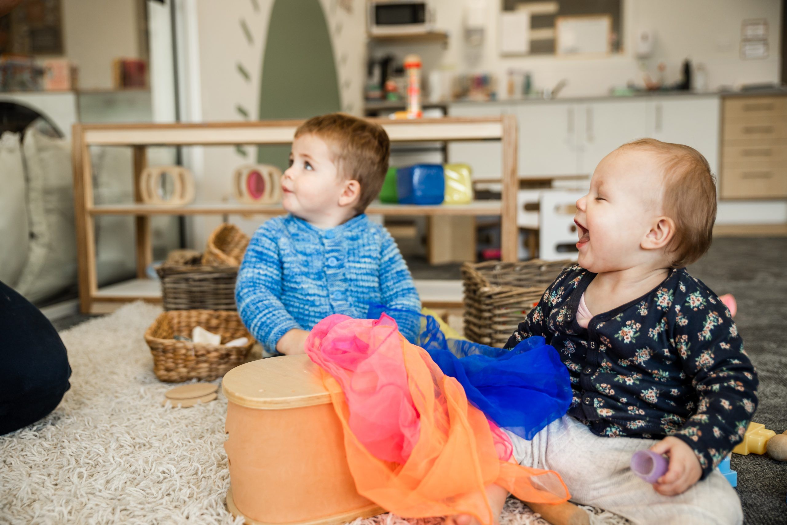 Nurture and Bloom | Babies laughing while playing with toys