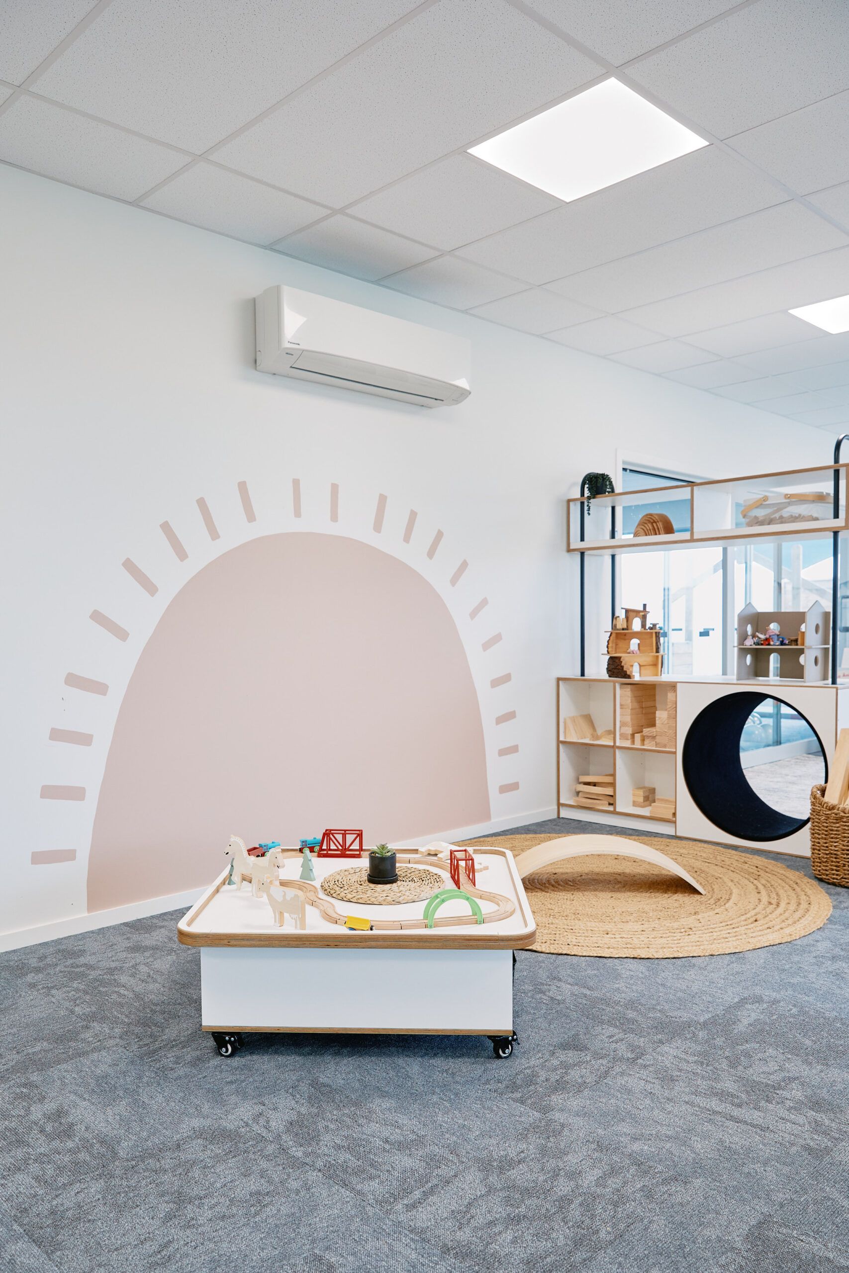 Nurture & Bloom | Indoor wooden play and learn area with hand-painted rainbow mural