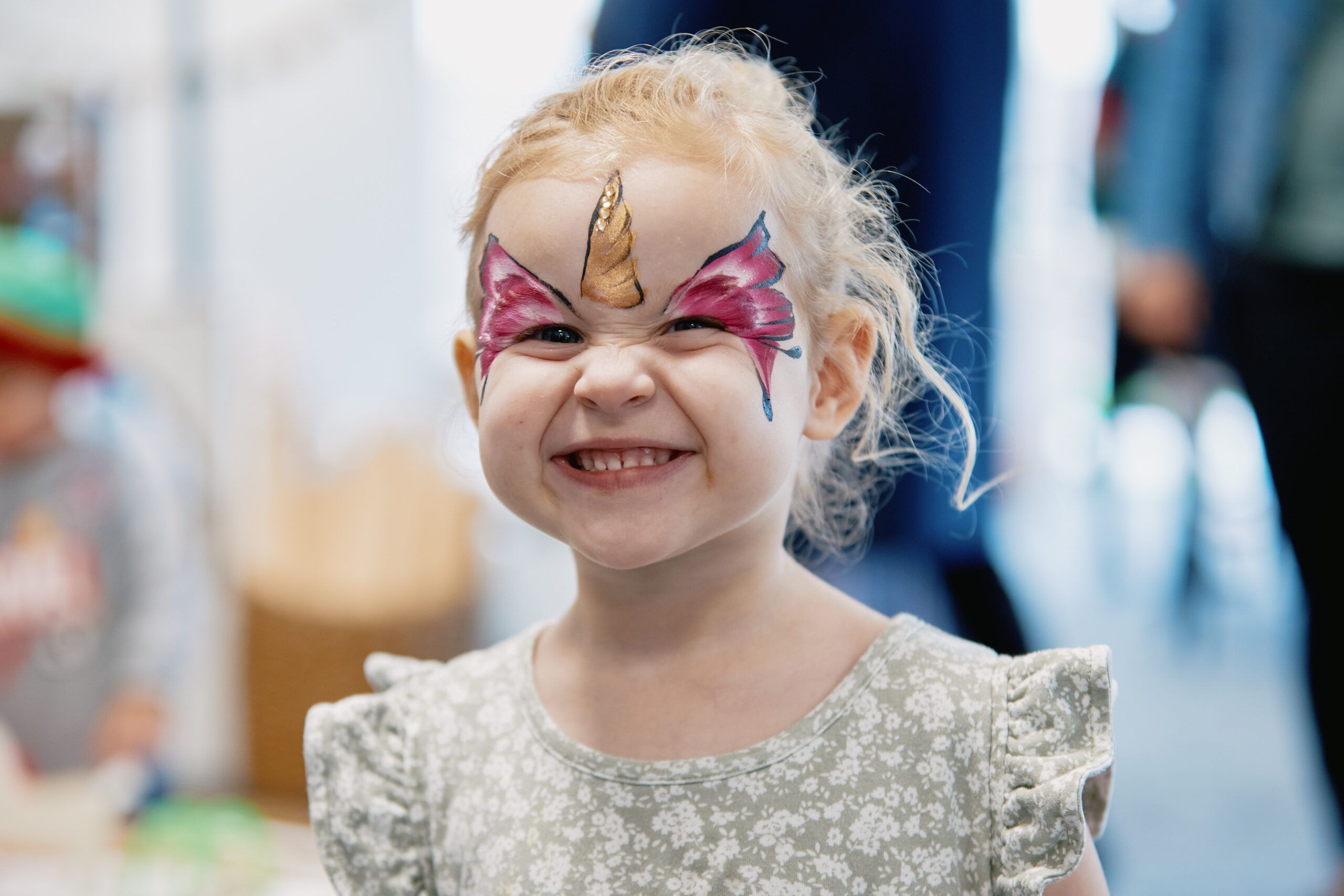 Nurture & Bloom | Child with a cute smile enjoying having her face painted