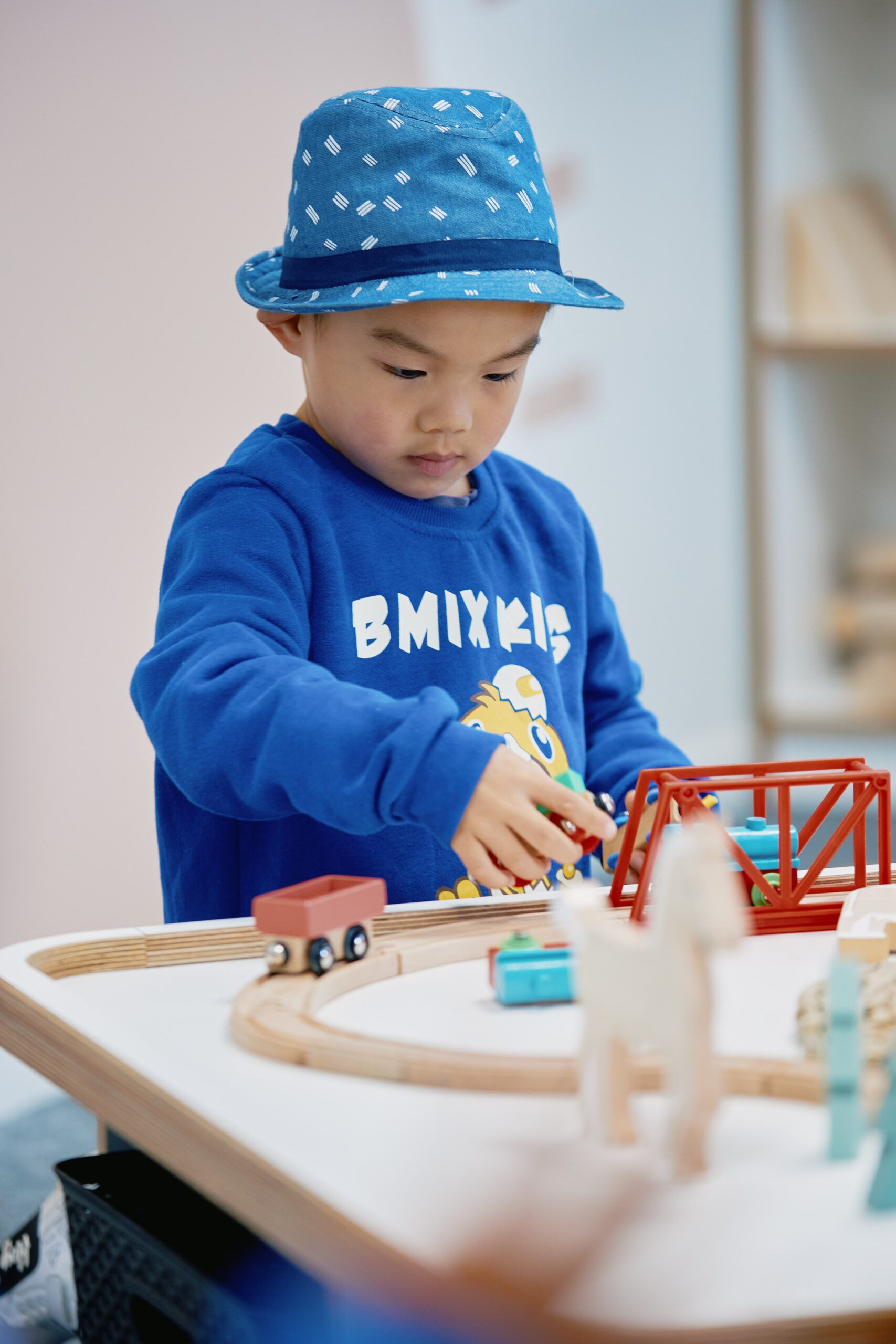 Nurture & Bloom | Child playing with wooden train set